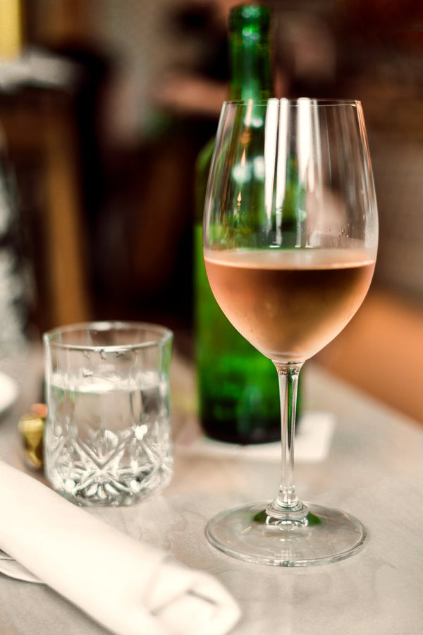 a glass of rose' wine on a table 