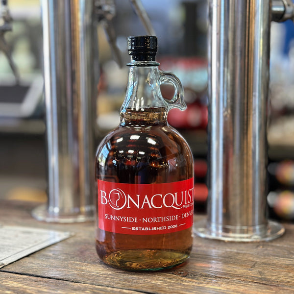 A one liter growler of Bonacquisti Wine sitting on the counter.