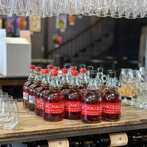 Ten bottles of Bonacquisti Wine in one liter growlers on the bar.