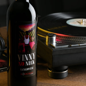 a bottle of Bonacquisti Wine Vinny No Neck Sangiovese next to turntable