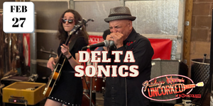 Al Chesis playing harmonica with his band in a winery setting, featuring 'Delta Sonics' text.