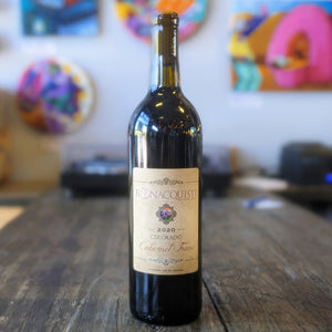 a bottle of Bonacquisti Wine Co 2020 Colorado Cabernet Franc sitting on the bar counter at the winery.